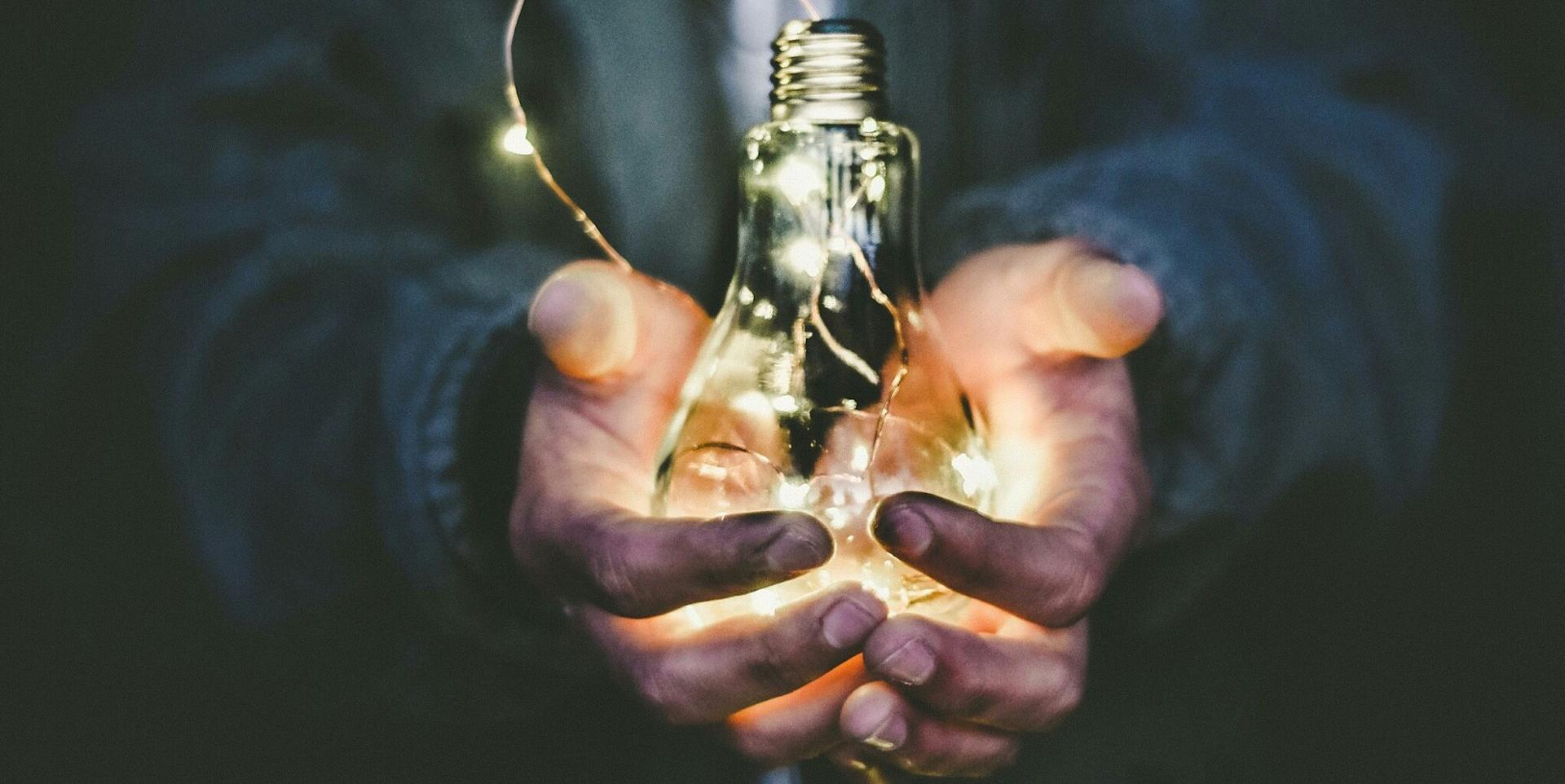 man holding incandescent bulb